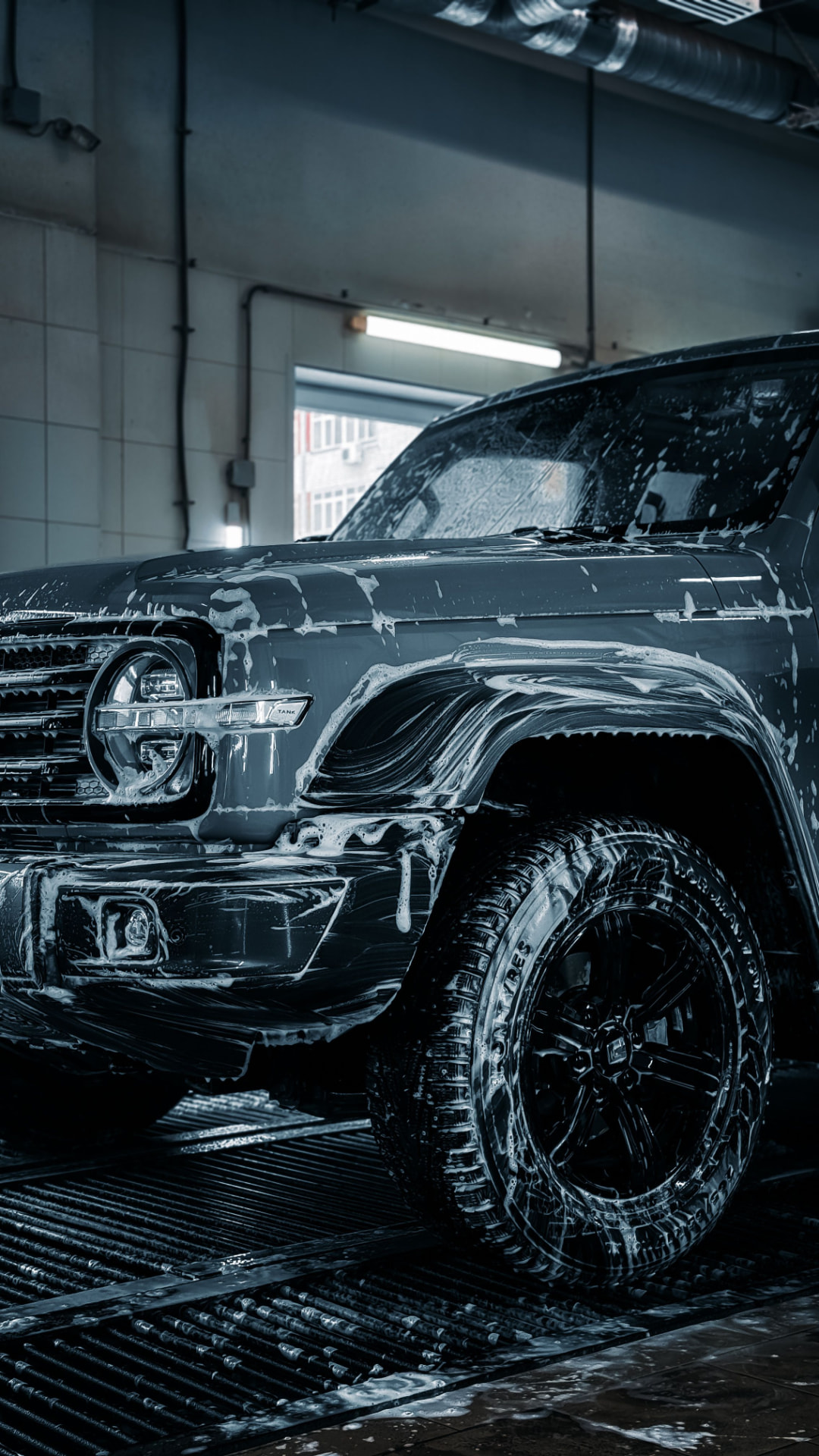 SUV covered in cleaning foam during an exterior wash